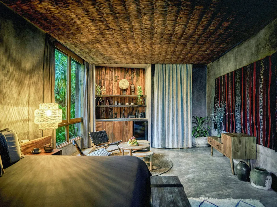 Spacious oceanfront suite interior at BE Destination Tulum with wood accents and large window