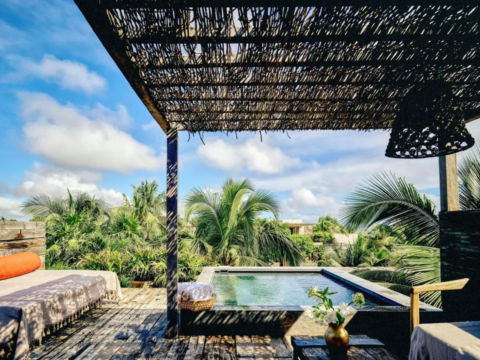 Shaded terrace with plunge pool and tropical palms at BE Destination Tulum.