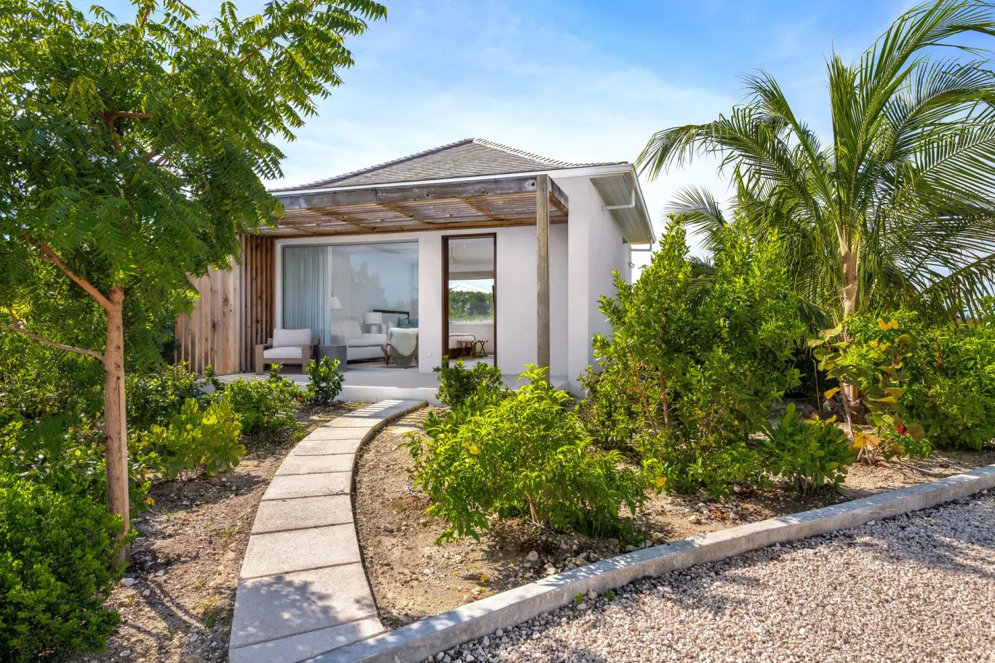 Garden path leading to a villa entrance and patio at Beach Enclave.