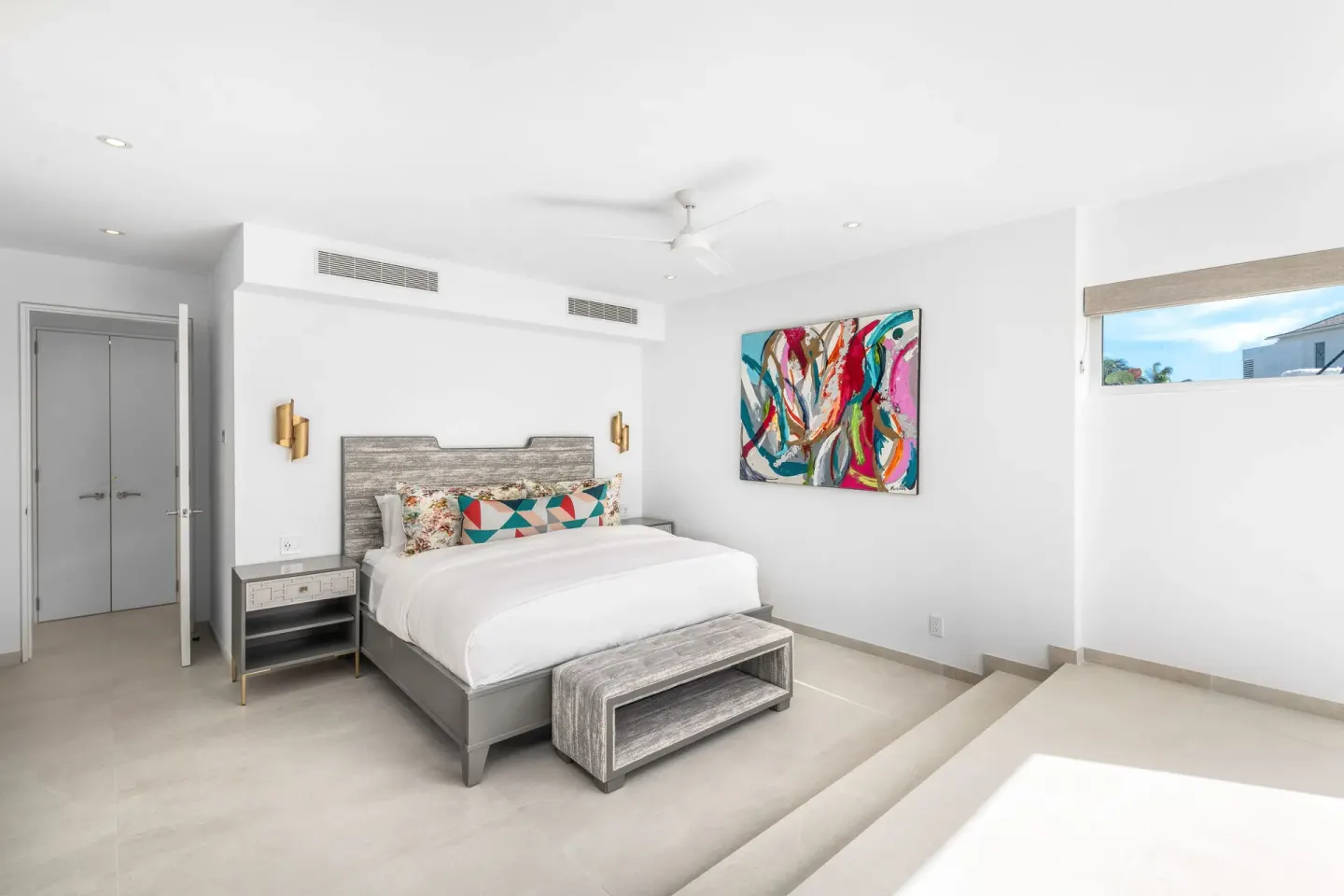 King bed guest room with abstract art and raised floor area at Beach Enclave.