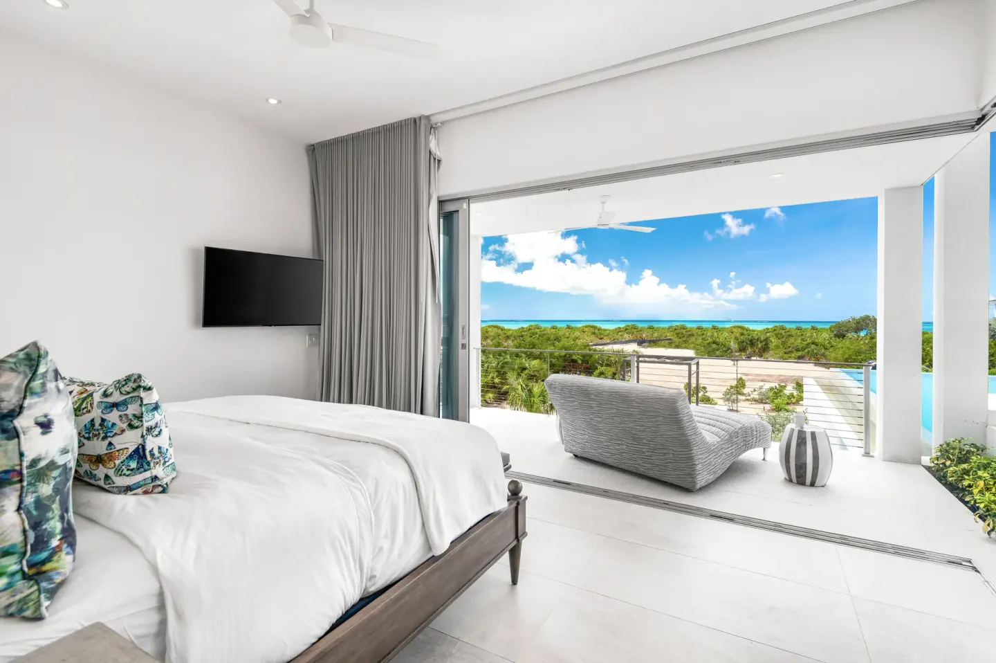 King bed guest room opening to a terrace with ocean view at Beach Enclave.