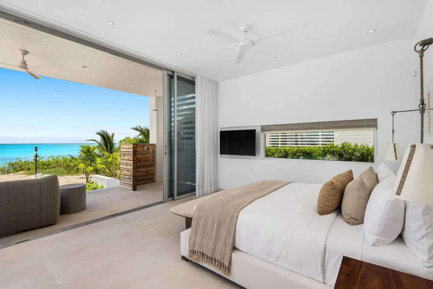 King bedroom with sliding doors to a shaded ocean-view terrace at Beach Enclave.