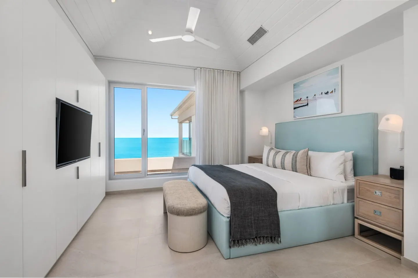 Ocean-view bedroom with king bed and wall-mounted TV at Beach Enclave.