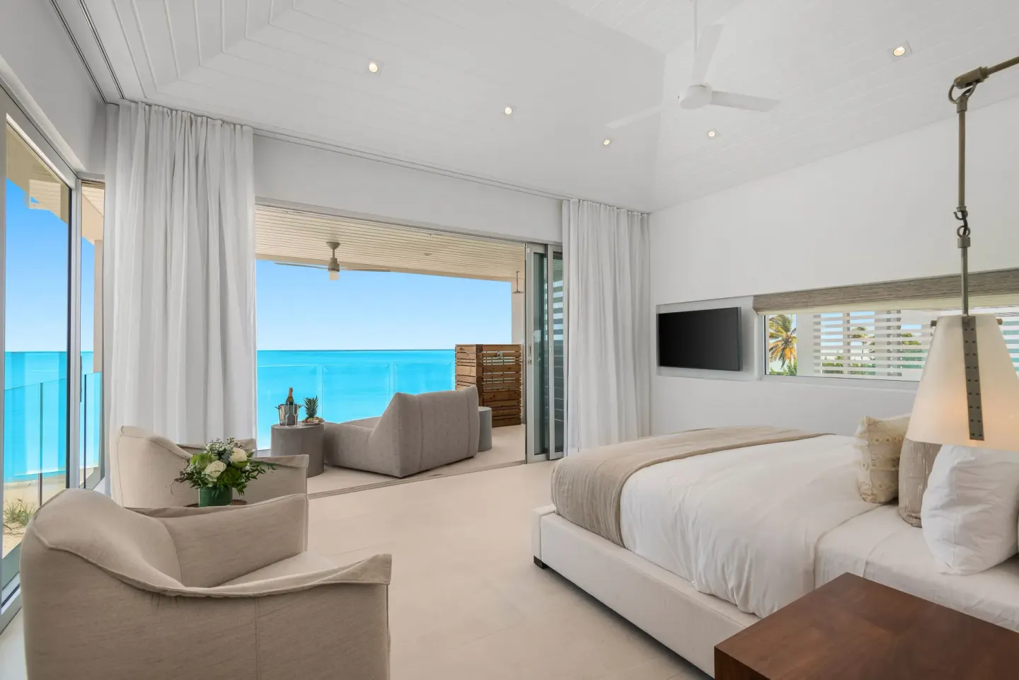 Oceanfront bedroom with terrace seating and a king bed at Beach Enclave.