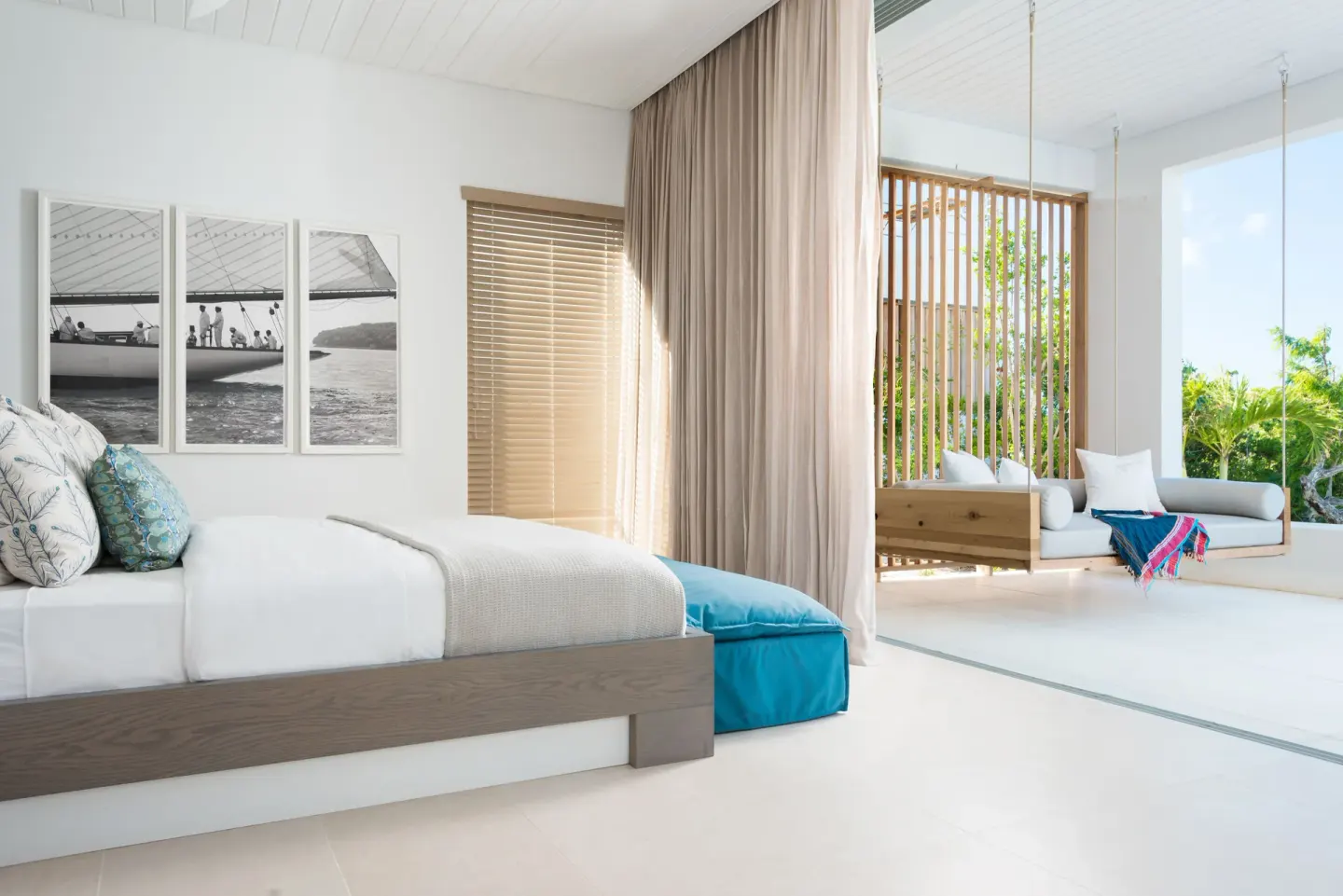 Bedroom with platform bed and hanging daybed by the terrace at Beach Enclave.