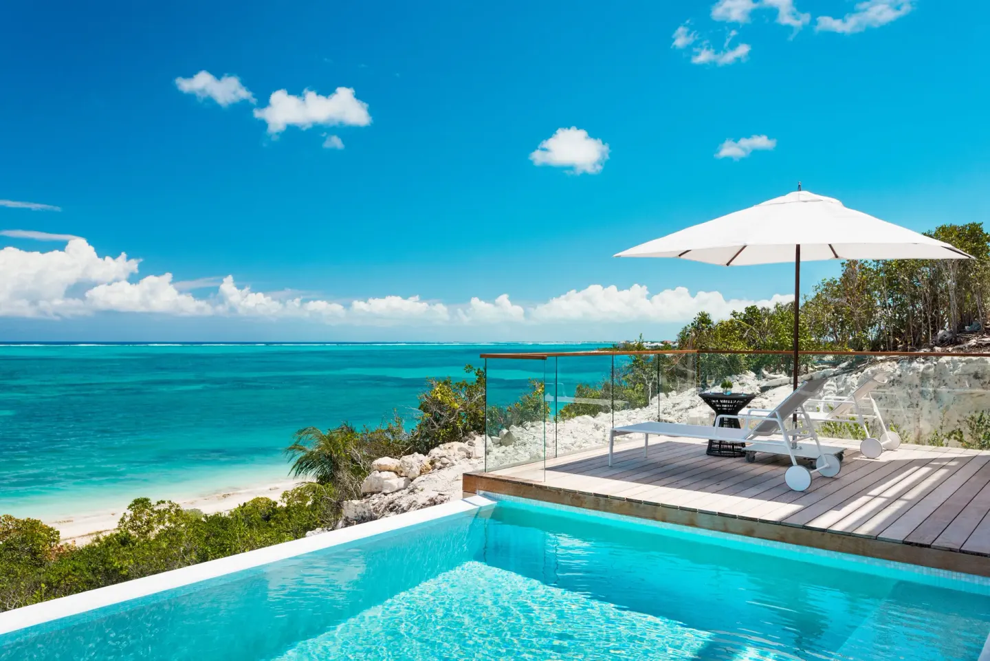 Private pool terrace with loungers and ocean view at Beach Enclave.
