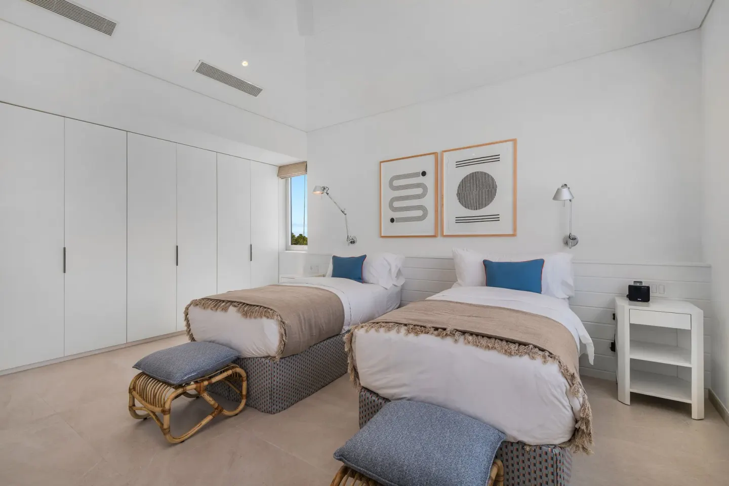 Twin bedroom with two beds and white built-in wardrobes at Beach Enclave.