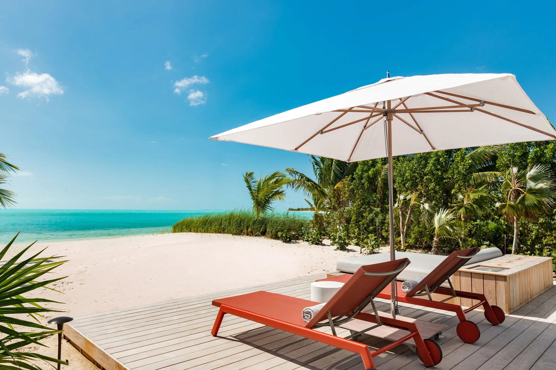 Long Bay 3 Bedroom Beach Enclave beachfront terrace with loungers and umbrella at Beach Enclave.