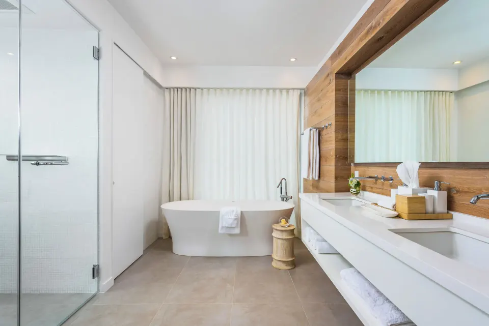 Modern villa bathroom with soaking tub, shower, and double vanity at Beach Enclave.