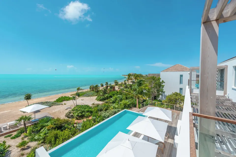 Villa balcony overlooking the pool, beach, and ocean at Beach Enclave.