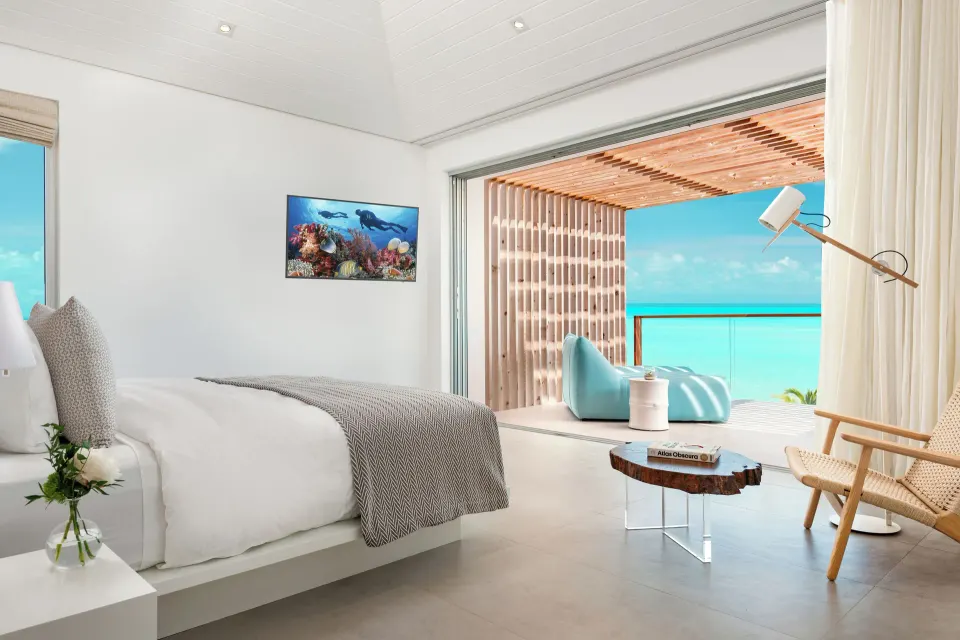 Bedroom with king bed, lounge seating, and ocean-facing balcony at Beach Enclave.