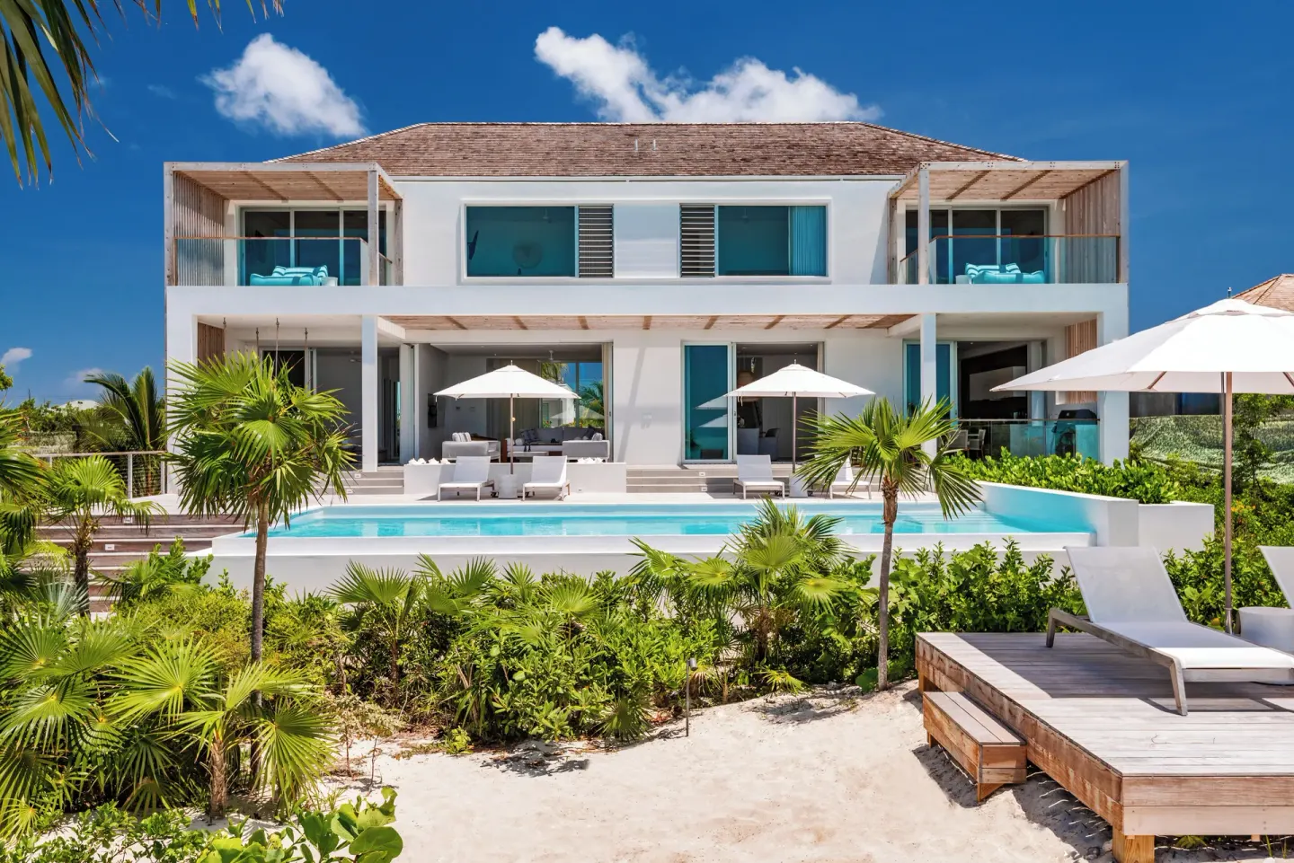 Two-story Long Bay villa exterior with pool, balconies, and beach deck at Beach Enclave.