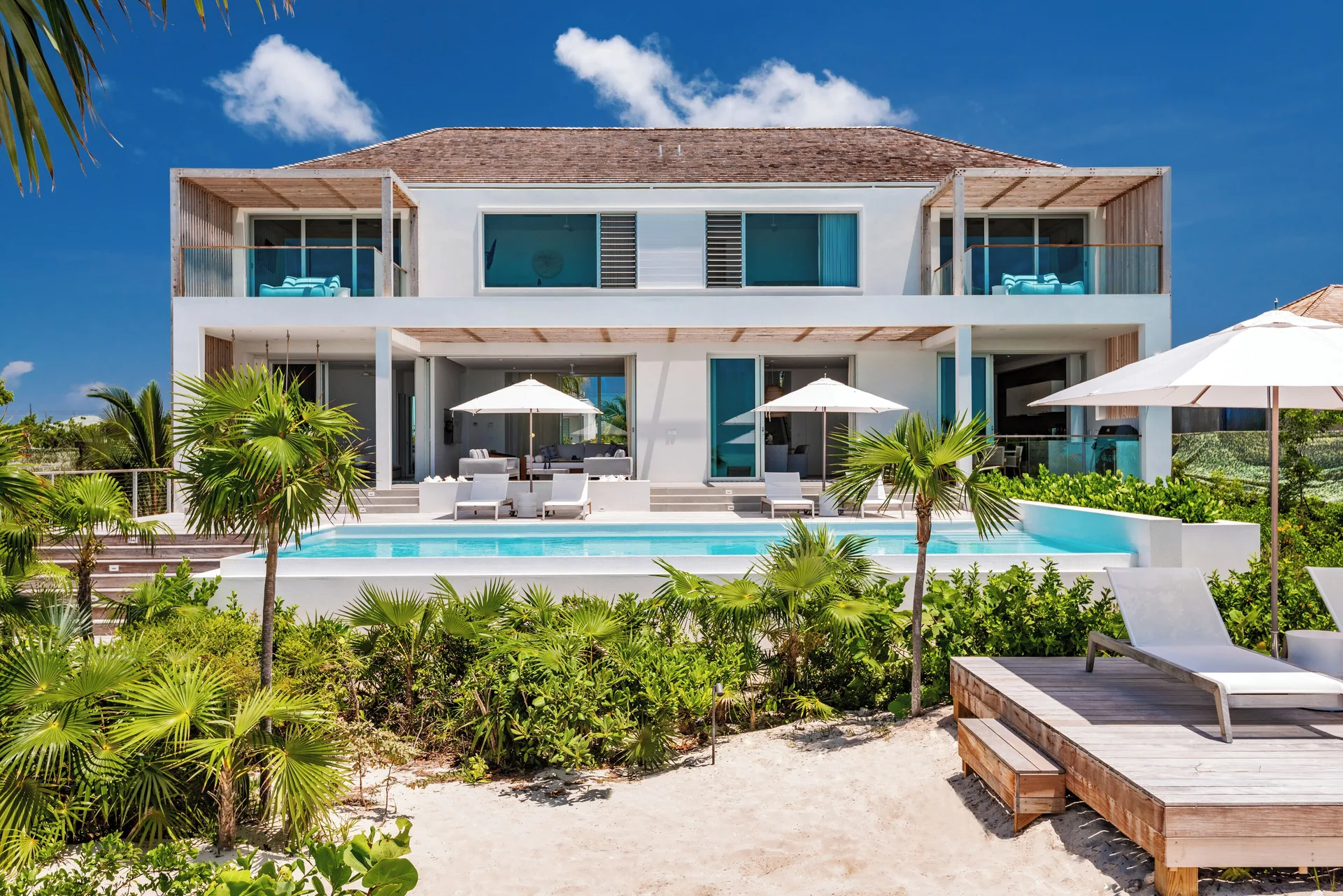 Two-story Long Bay villa exterior with pool, balconies, and beach deck at Beach Enclave.