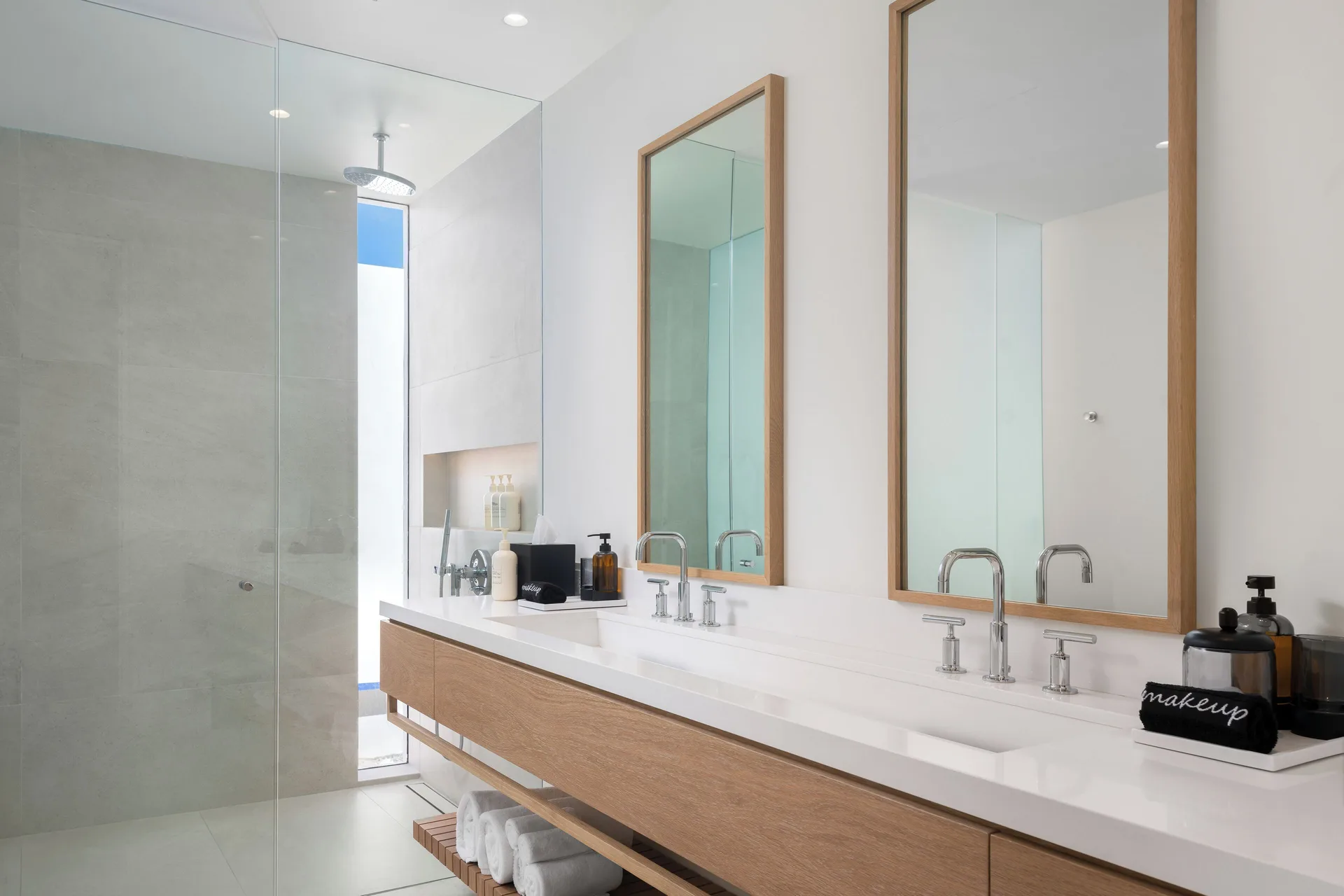 Bathroom with double vanity, mirrors and glass shower at Beach Enclave.