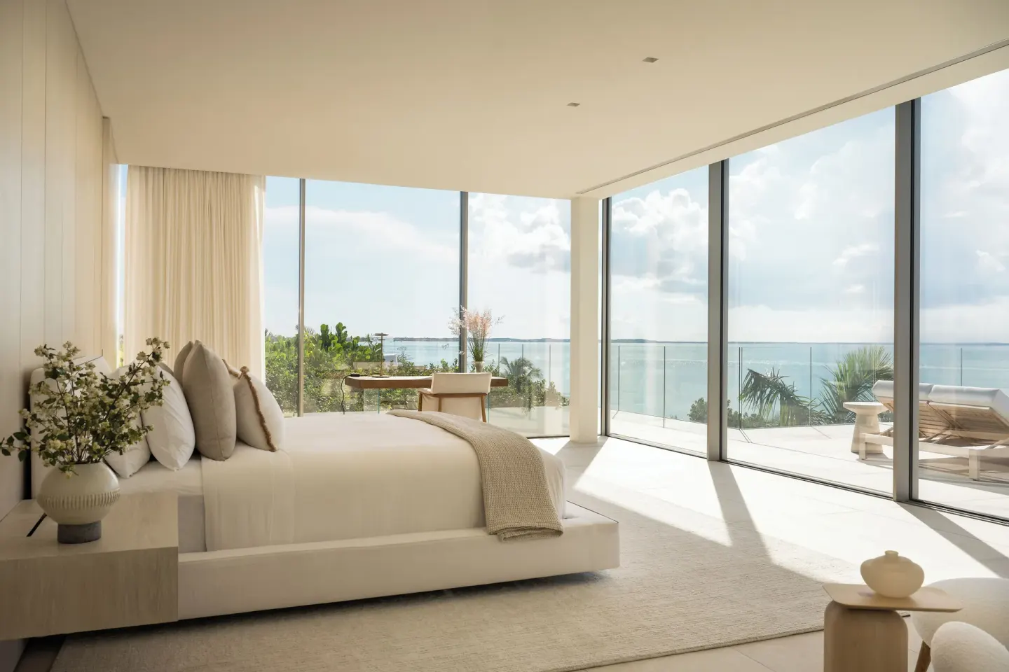 Ocean-view bedroom with a large bed and floor-to-ceiling windows at Beach Enclave.