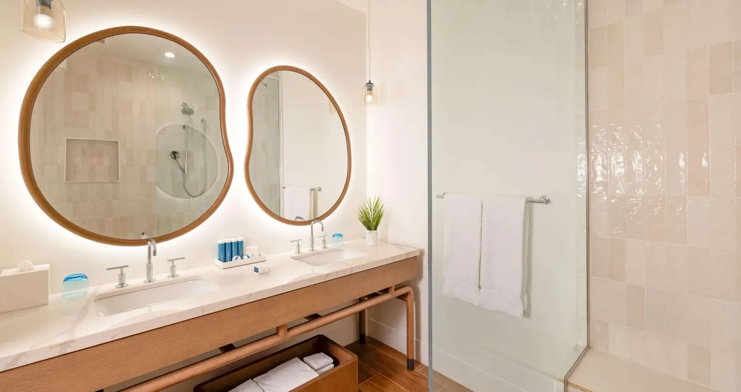 Bright bathroom with double sinks and glass shower at Beaches Negril Resort.