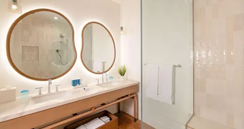 Bright bathroom with double sinks and glass shower at Beaches Negril Resort.