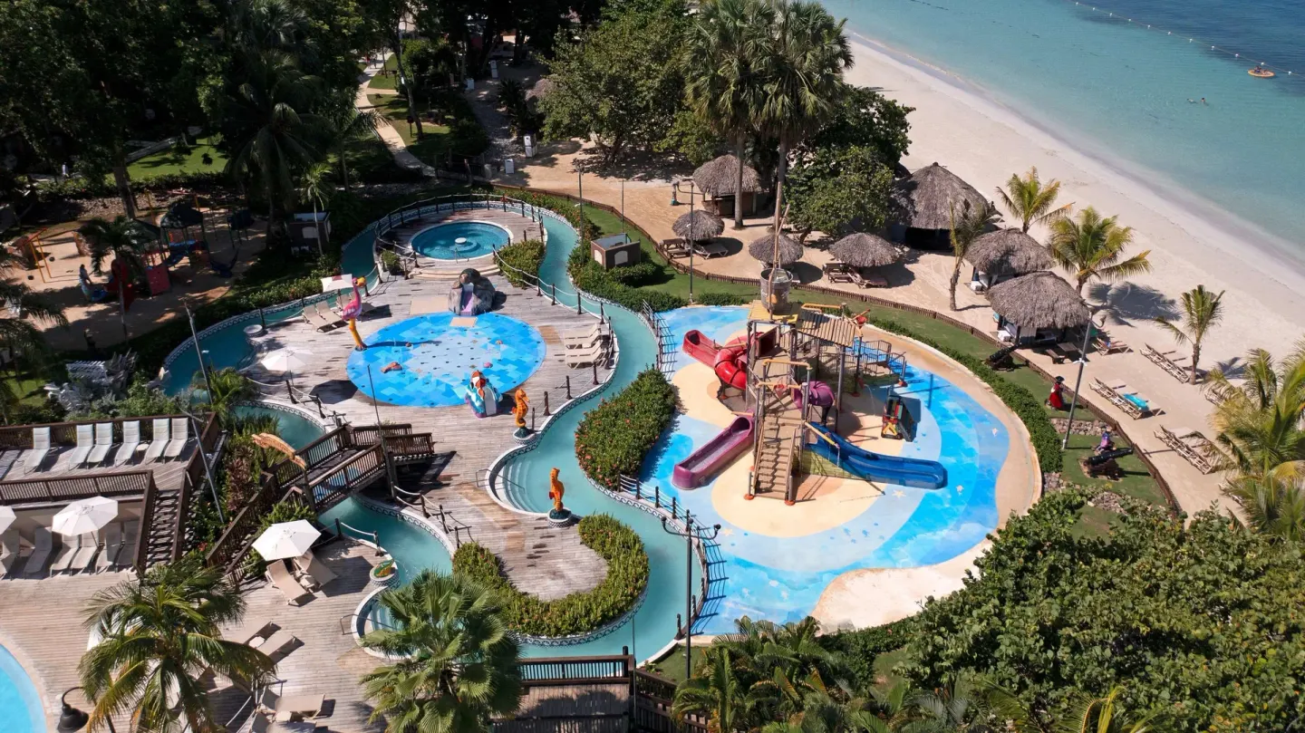 Aerial view of beachside pools and a children's water play area at Beaches Negril Resort.