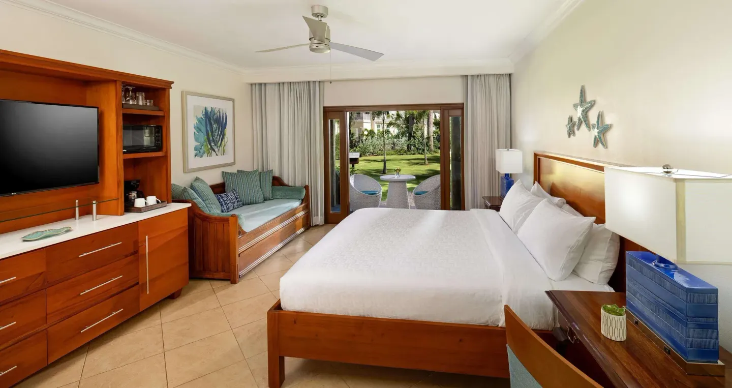 King bed guest room with daybed and garden patio at Beaches Negril Resort.