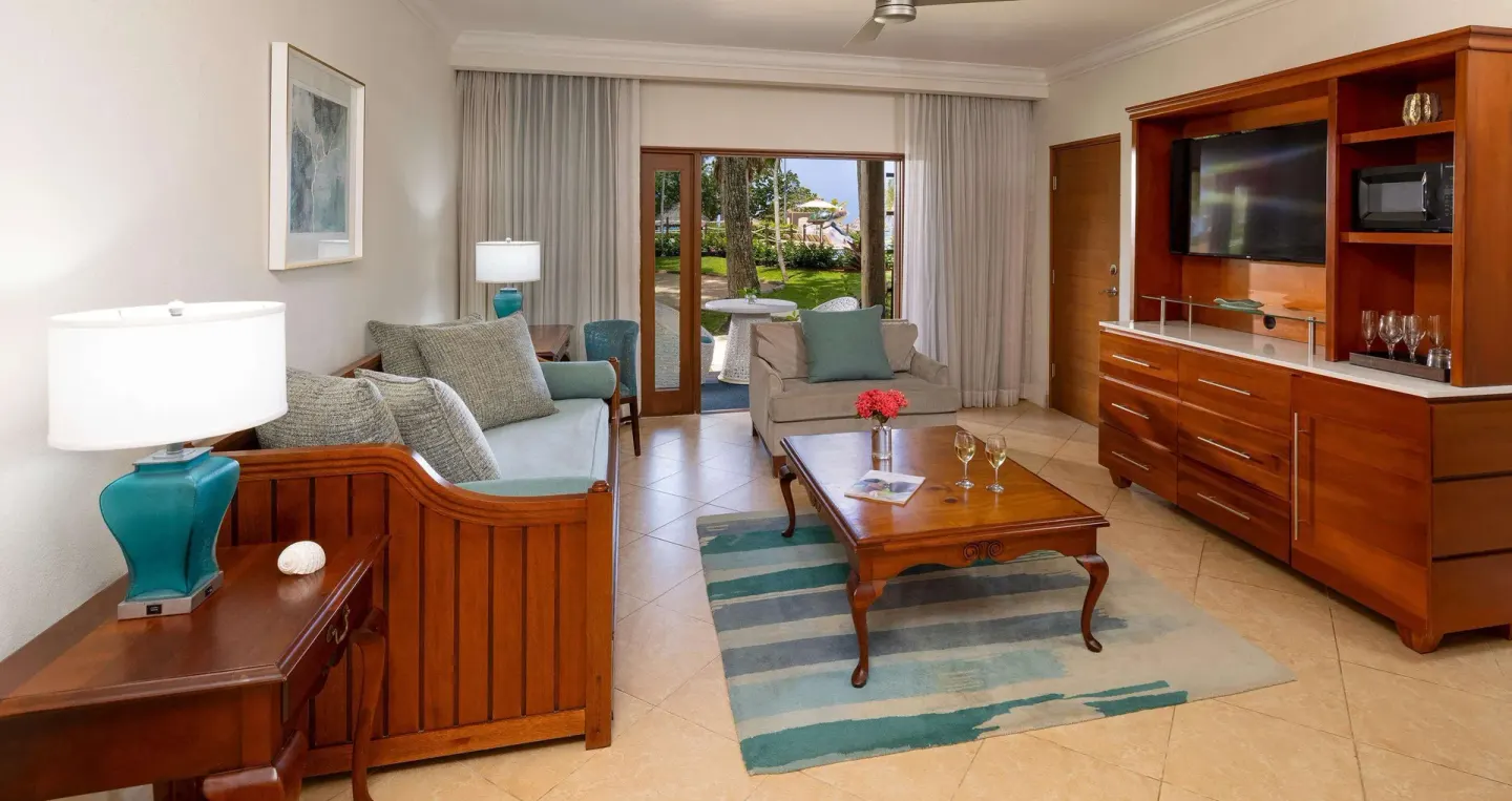Living area with sofas, coffee table, and patio doors at Beaches Negril Resort.