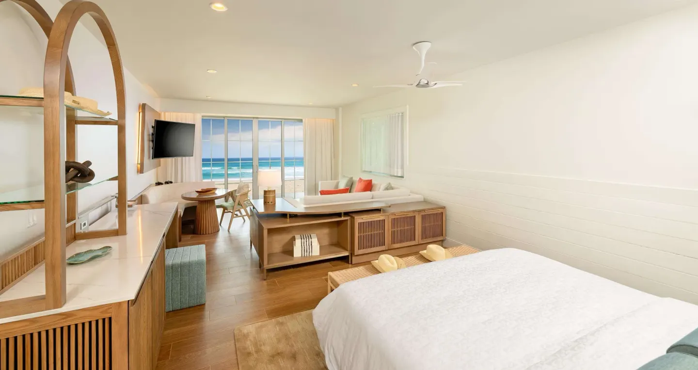 King bed guest room with sitting area and ocean-facing windows at Beaches Negril Resort.