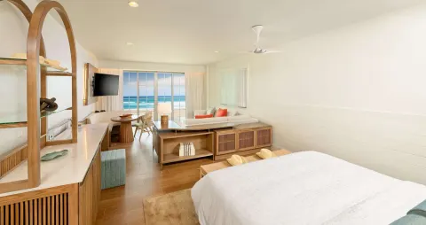 King bed guest room with sitting area and ocean-facing windows at Beaches Negril Resort.