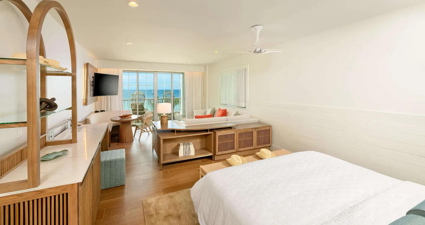 Ocean-view king bed room with modern seating at Beaches Negril Resort.