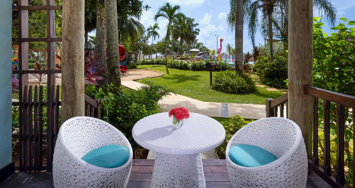 Patio seating looking toward gardens and play structures at Beaches Negril Resort.