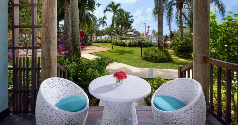 Patio seating looking toward gardens and play structures at Beaches Negril Resort.