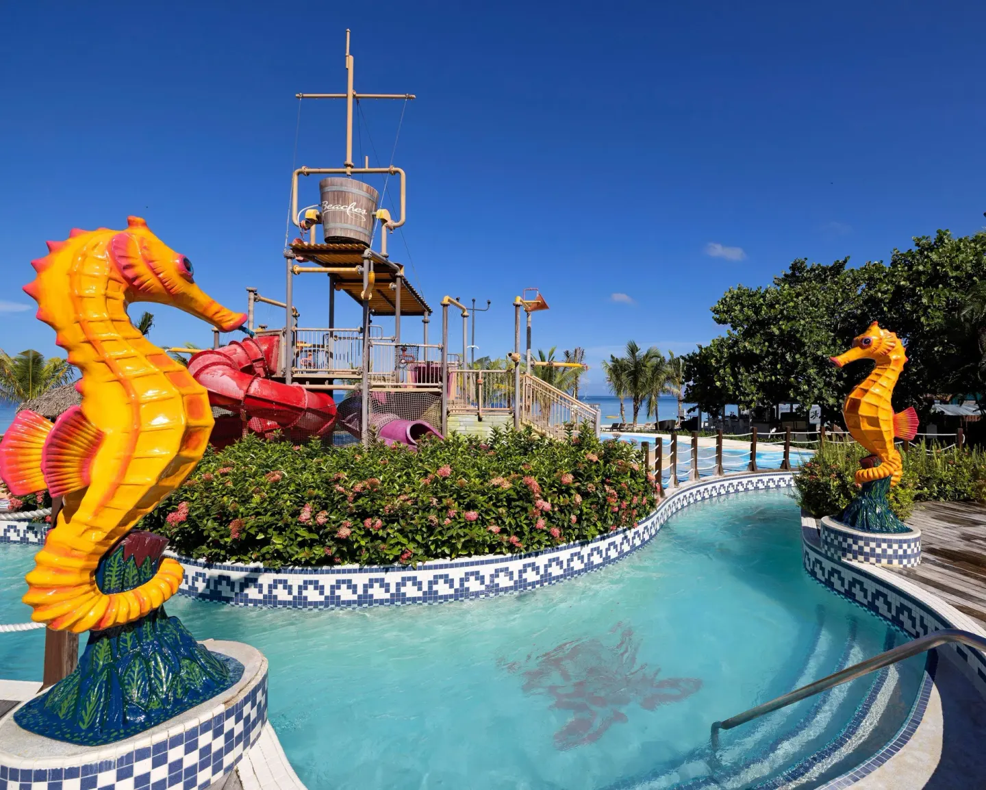 Seahorse sculptures frame a pirate-themed pool area at Beaches Negril Resort.