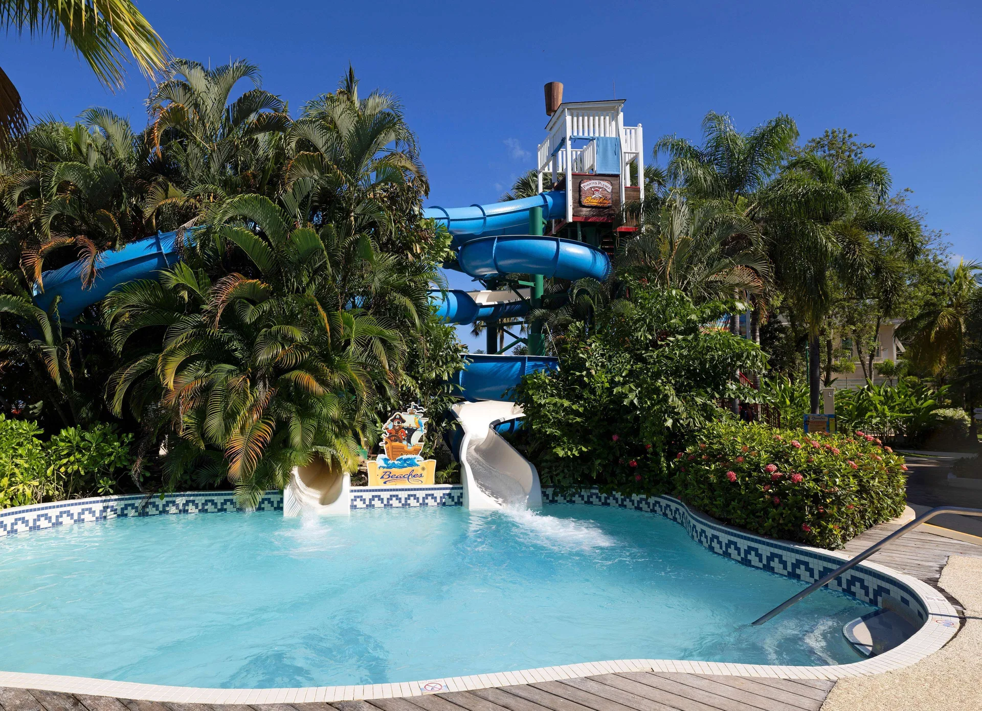 Blue and white waterslides empty into a pool at Beaches Negril Resort.
