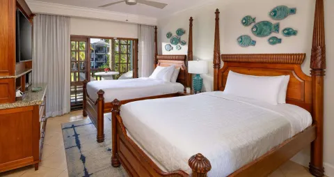 Two poster beds in a Concierge Tropical Oceanview Junior Suite at Beaches Negril Resort.
