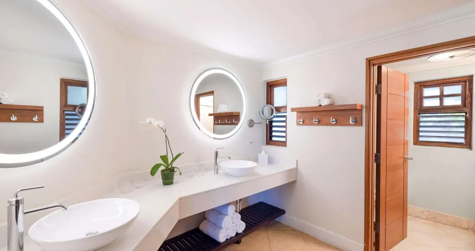Suite bathroom with double sinks and round mirrors at Beaches Negril Resort.
