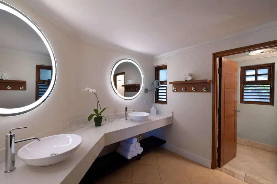Tropical Oversized Concierge Suite bathroom vanity with lit mirrors at Beaches Negril Resort.