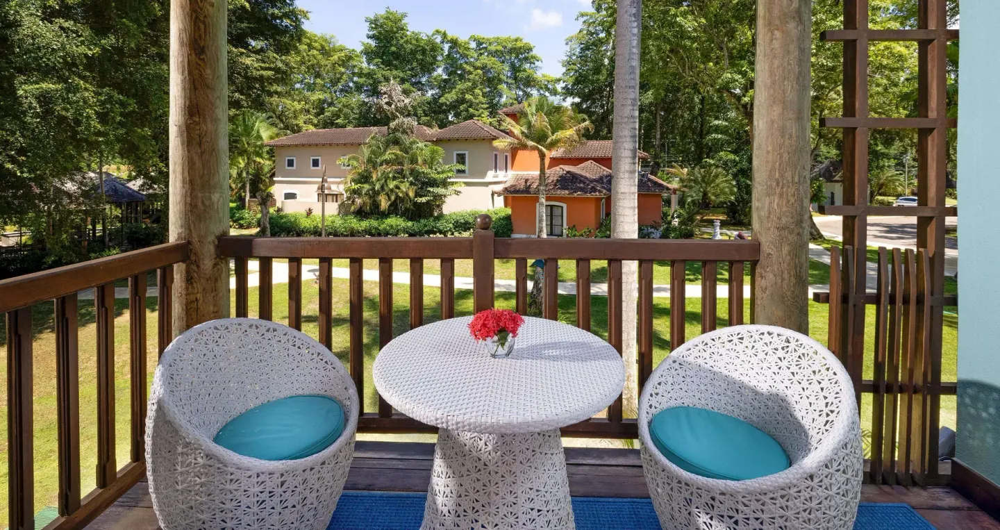 Garden view balcony with white chairs and table at Beaches Negril Resort.