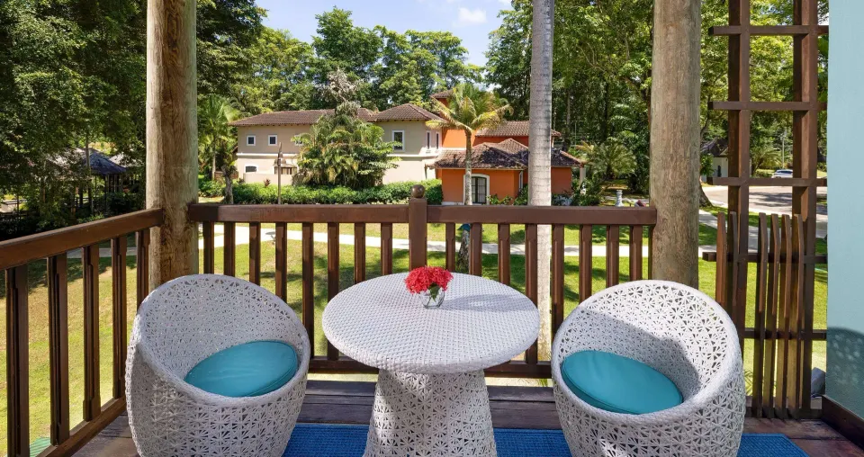 Garden view balcony with white chairs and table at Beaches Negril Resort.