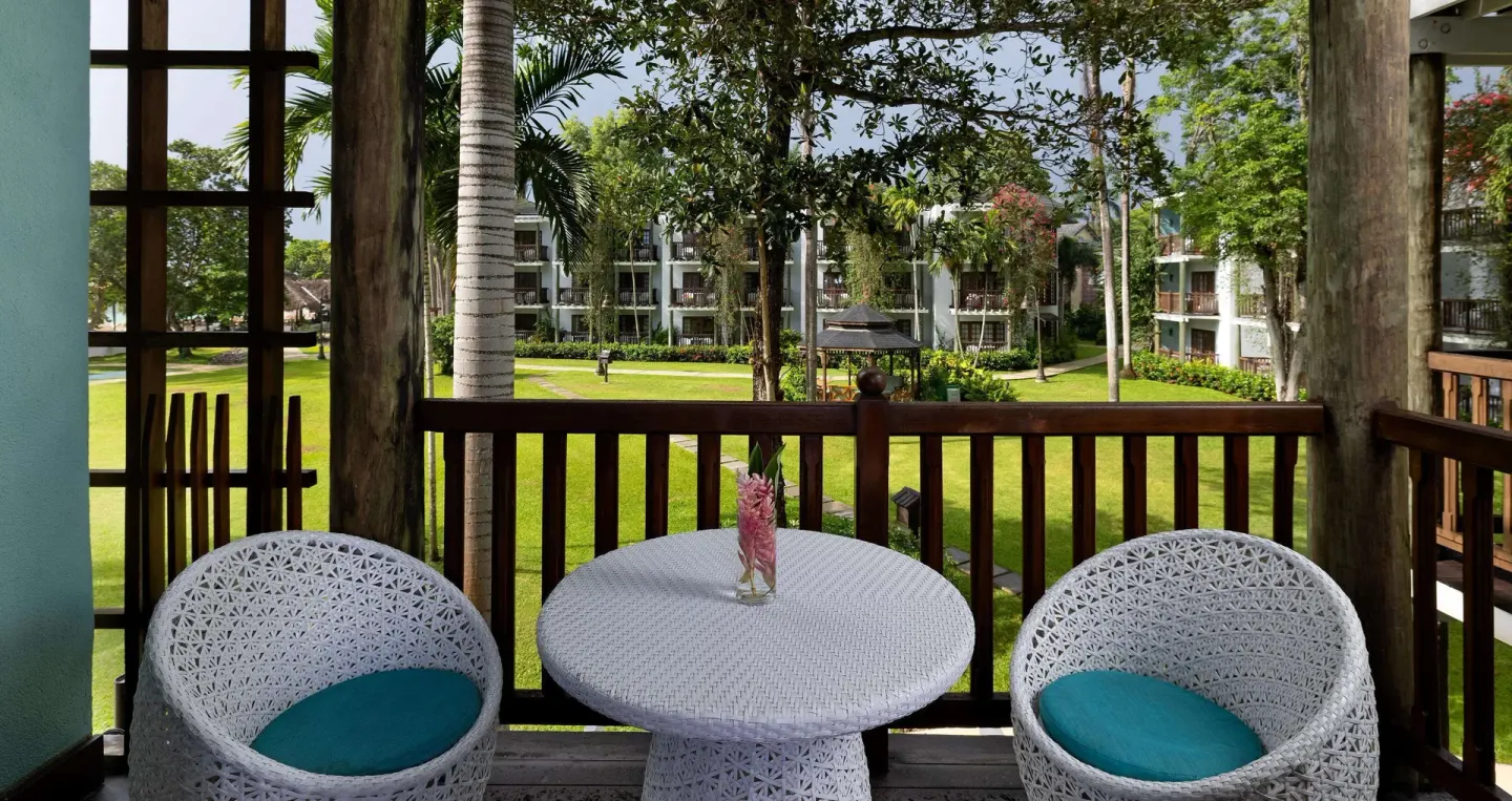 Tropical Concierge balcony with table, chairs, and lawn view at Beaches Negril Resort.