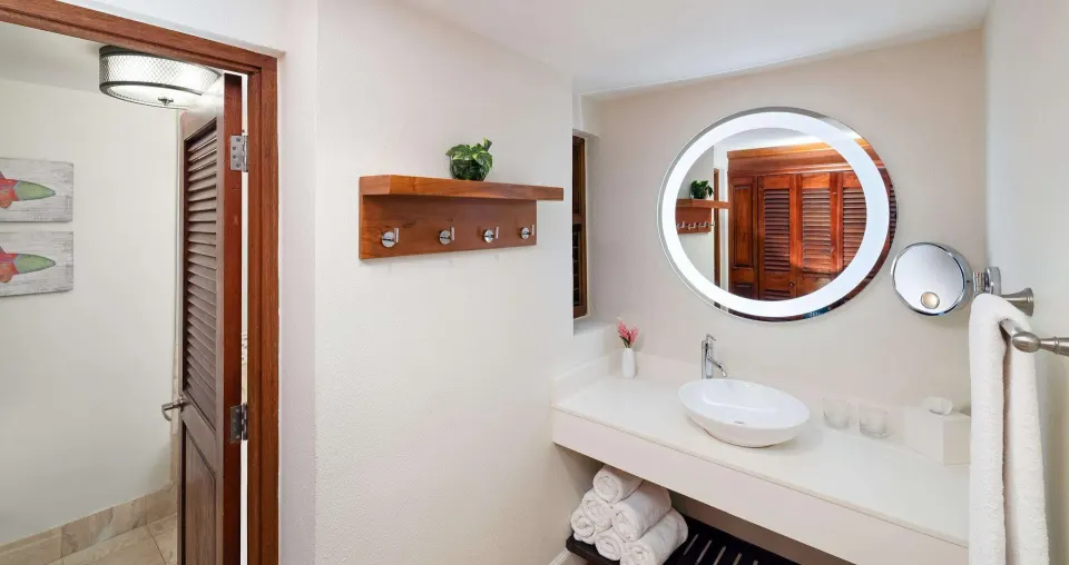 Tropical Concierge bathroom with round mirror and vessel sink at Beaches Negril Resort.