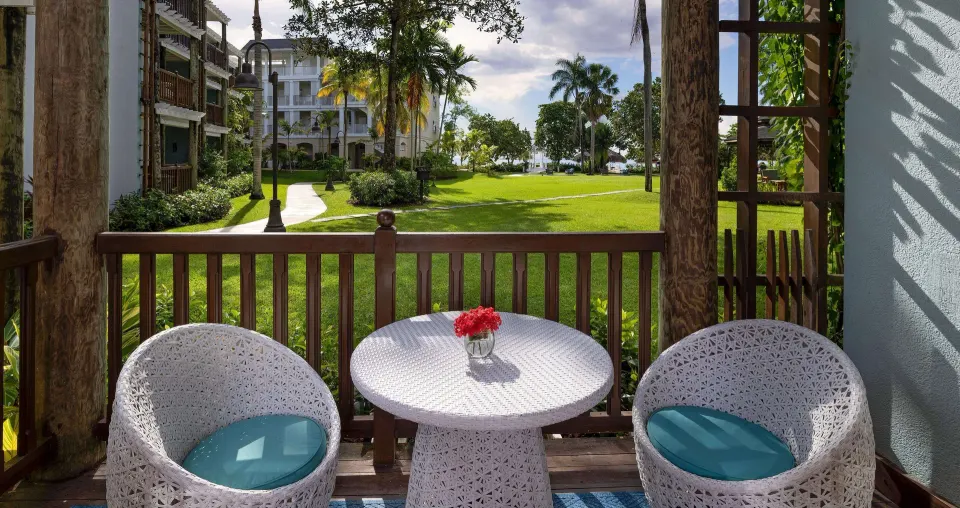 Tropical Oceanview Concierge balcony seating and lawn view at Beaches Negril Resort.