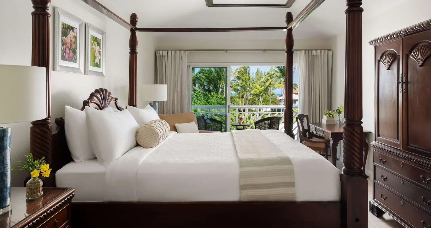 Four-poster king bed with balcony view in a suite at Beaches Turks & Caicos.