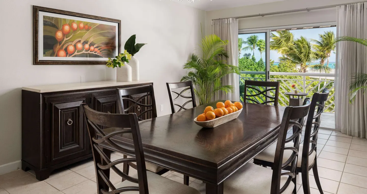 Dining area with dark wood table and ocean-view balcony at Beaches Turks & Caicos.