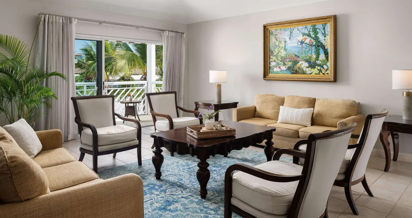 Living room with sofas, armchairs, and balcony access at Beaches Turks & Caicos.