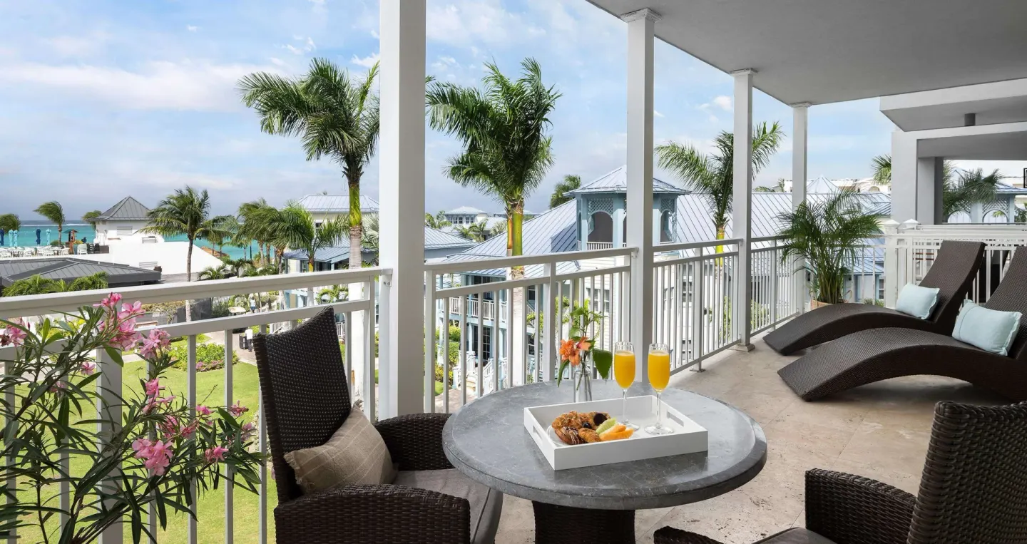 Ocean-view balcony with loungers and a table at Beaches Turks & Caicos.