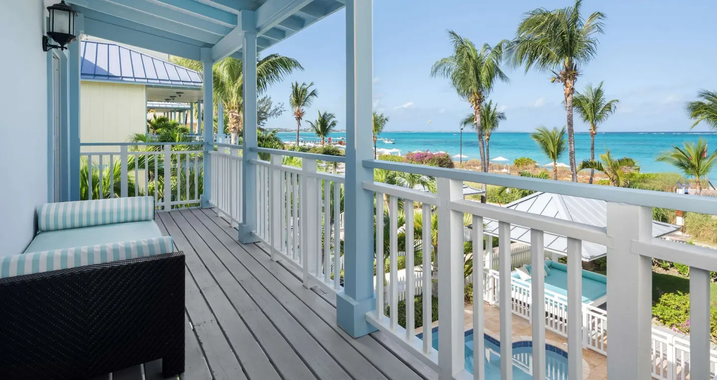 Covered balcony with striped lounge and ocean view at Beaches Turks & Caicos.