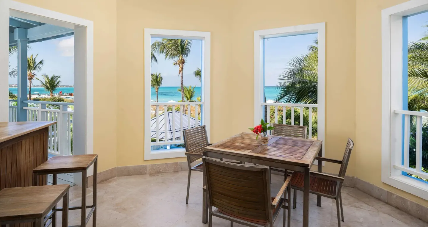 Indoor dining nook with wooden table and ocean views at Beaches Turks & Caicos.