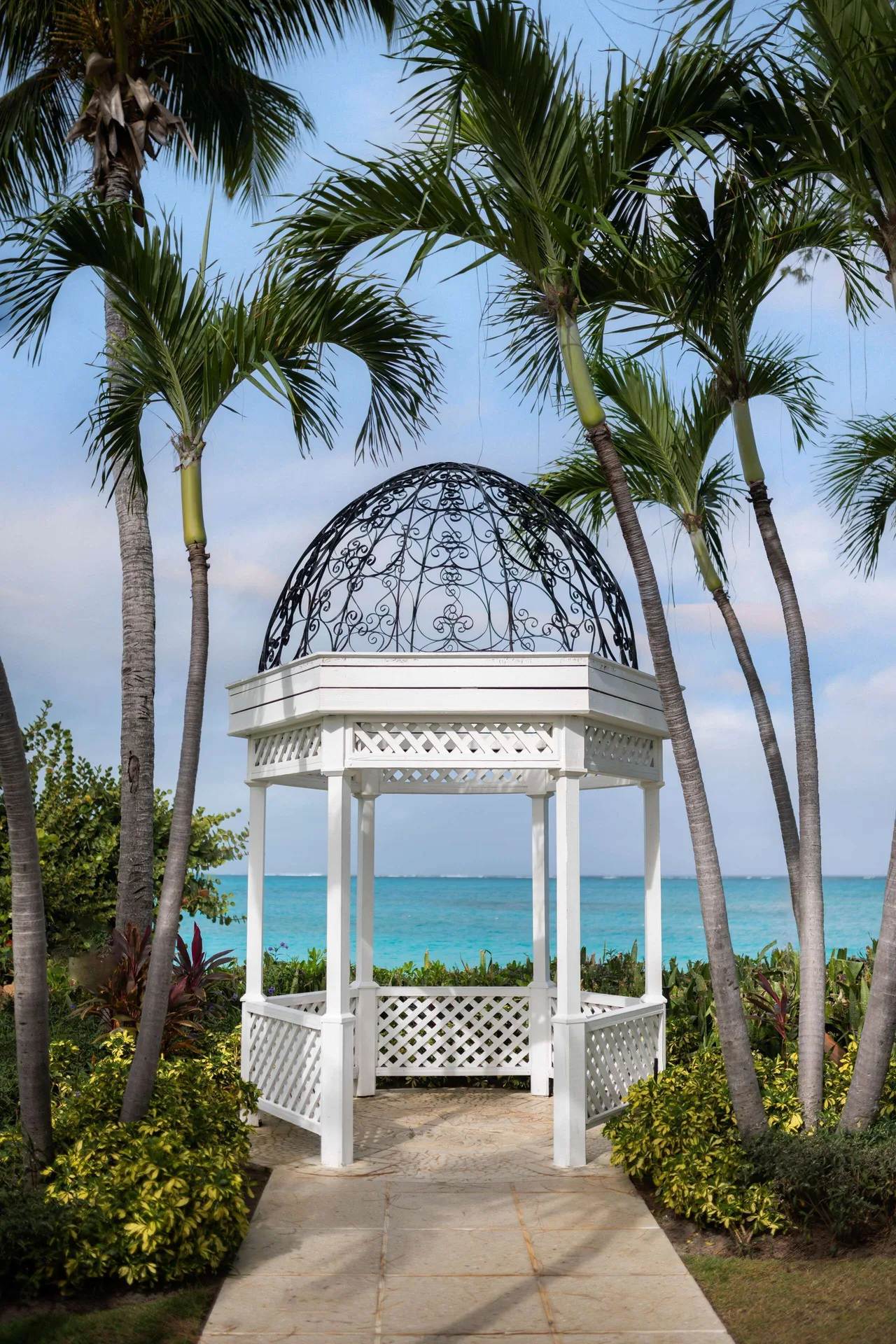 White garden gazebo framed by palms and ocean at Beaches Turks & Caicos.
