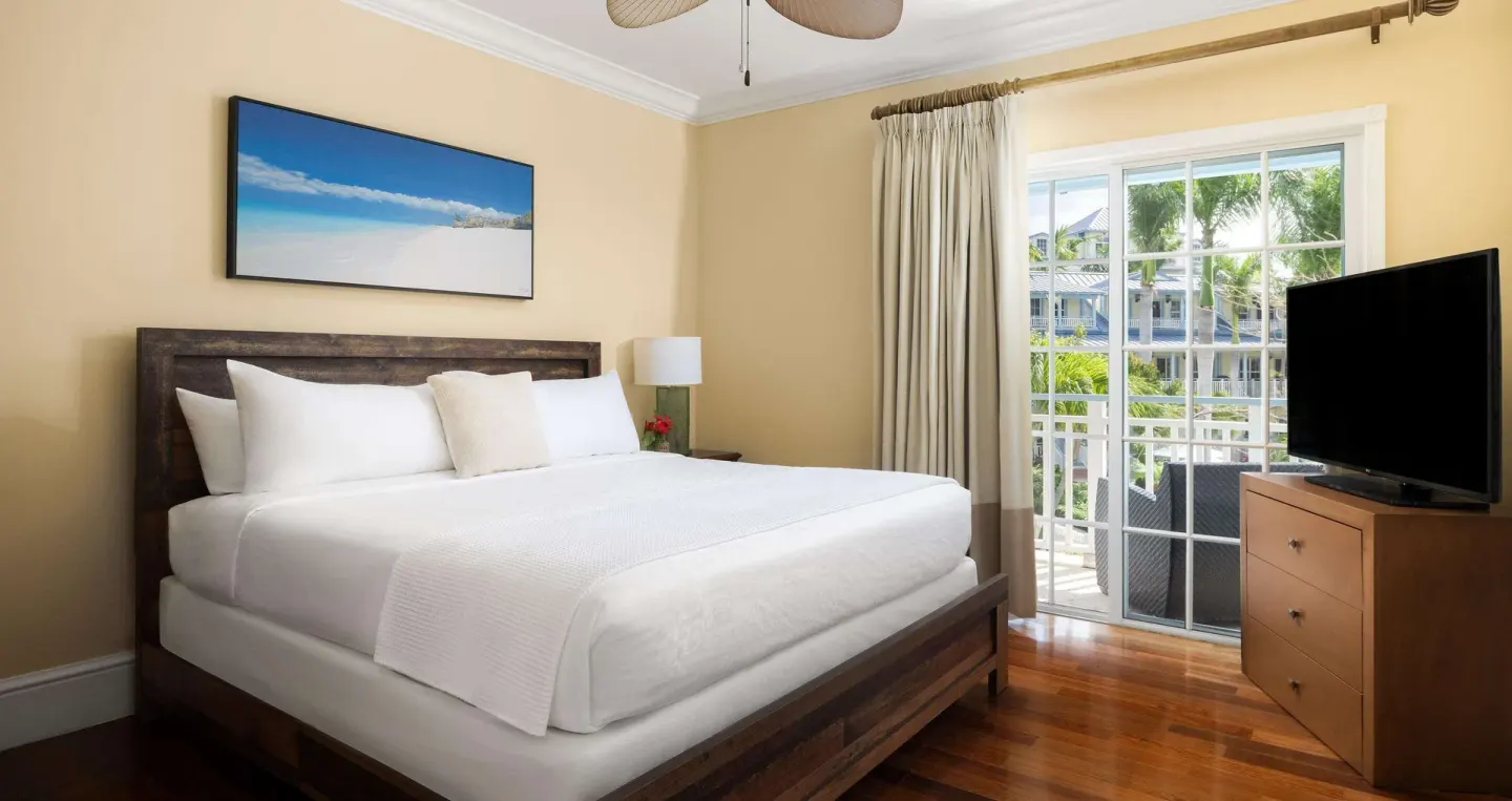 King bedroom with TV, balcony doors, and resort view at Beaches Turks & Caicos.