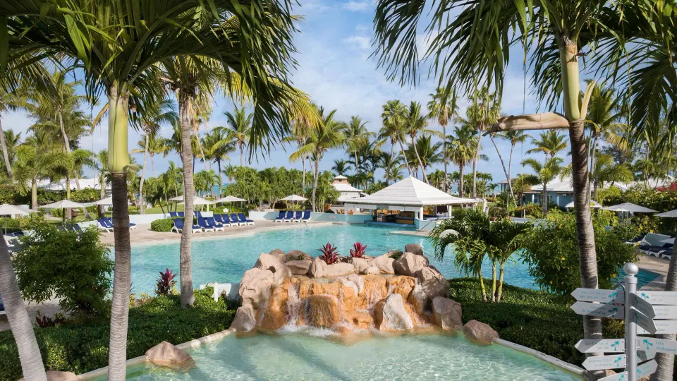 Tropical pool with rock waterfall and palm trees at Beaches Turks & Caicos.