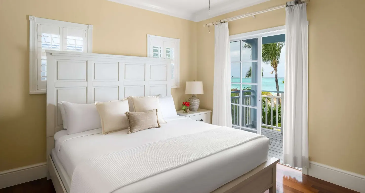 White king bed beside balcony doors with ocean view at Beaches Turks & Caicos.