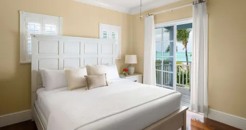 White king bed beside balcony doors with ocean view at Beaches Turks & Caicos.